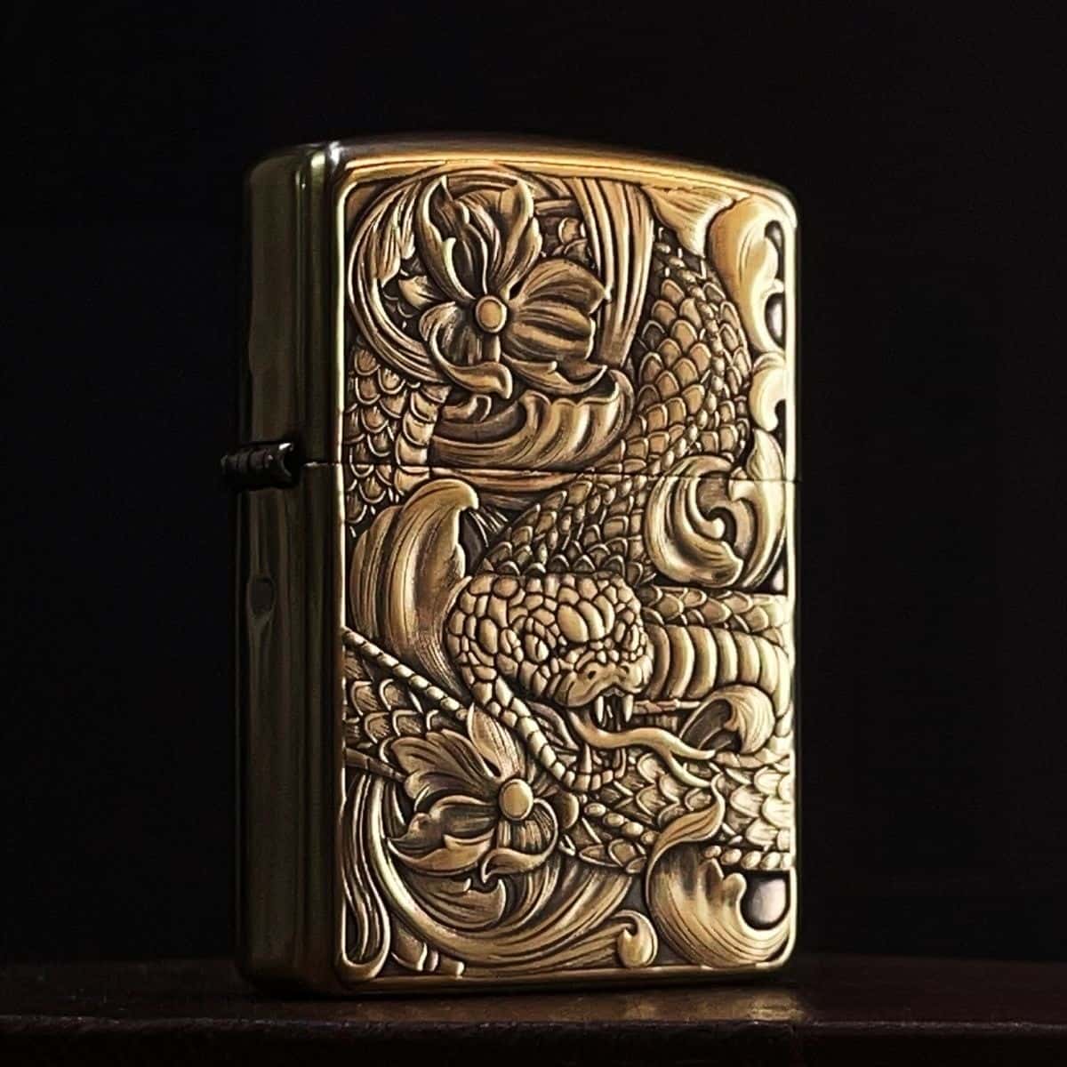Close‑up of detailed dragon scales and lotus flower 3D carving on brass lighter